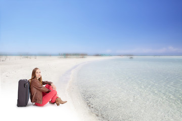 Woman with a suitcase on the sea beach