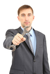 Young businessman with wrench isolated on white.