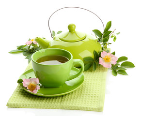Cup and teapot of herbal tea with hip rose flowers, isolated