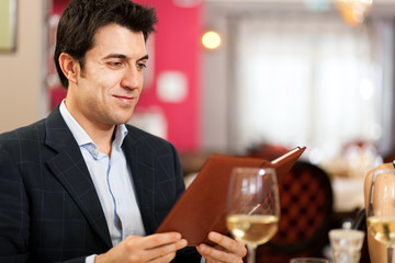 Man reading a menu in an elegant restaurant