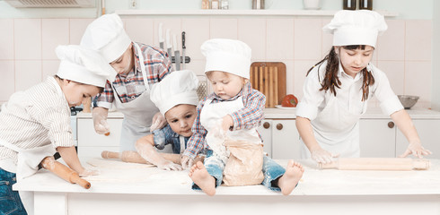 happy little chefs preparing dough in the kitchen with their