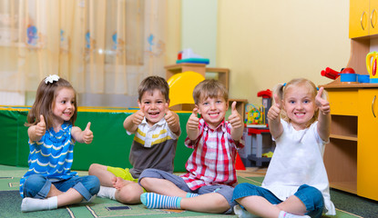 Excited children holding thumbs up