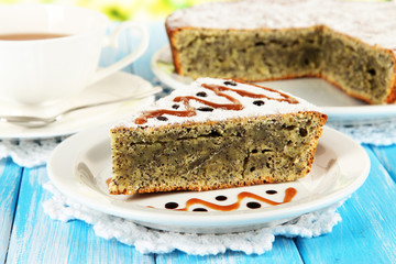 Delicious poppy seed cake with cup of tea on table close-up