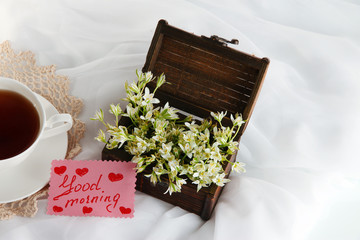 Composition with spring flowers and cup of tea