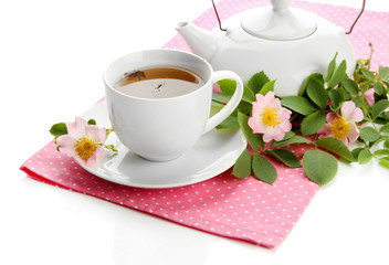 Cup and teapot of herbal tea with hip rose flowers, isolated
