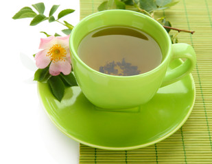 Cup of herbal tea with hip rose flower, isolated on white