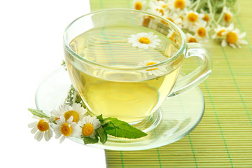 Cup of herbal tea with wild camomiles and mint, isolated