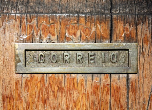 Mail slot, located in the middle of a wooden door