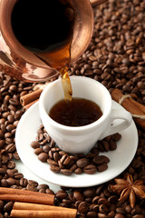 Cup and pot of coffee on coffee beans background