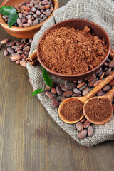 Cocoa powder and cocoa beans  on wooden background