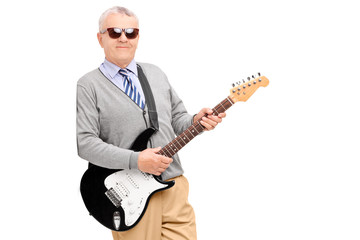 Mature man with guitar leaning against wall