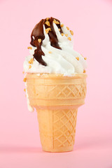 Tasty ice cream with chocolate, on pink background