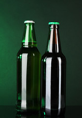 Bottles of beer on green background