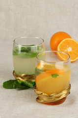 Lemonade in glasses on fabric background close-up