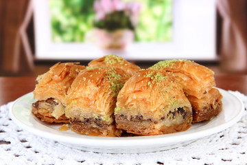 Sweet baklava on plate on table in room