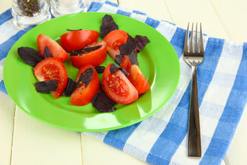 Salad of fresh tomatoes with basil leaves