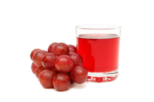 Glass with juice and grapes isolated on white background