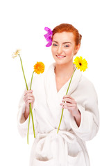 Obraz na płótnie Canvas Woman in bathrobe smiling with flowers