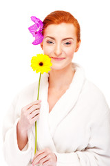 Woman in bathrobe smiling with flower
