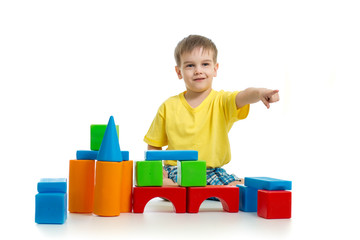 kid playing with colorful building blocks and pointing direction