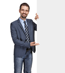 Smiling businessman showing large blank signboard