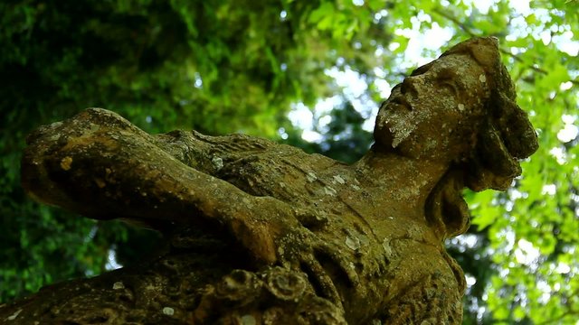A face of very old statue in the park.