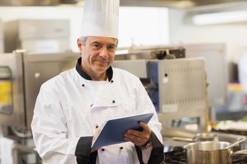 Chef using his digital tablet and looking at camera