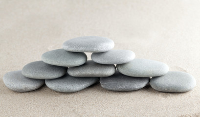 Fototapeta na wymiar The group of stones lies on small sea sand