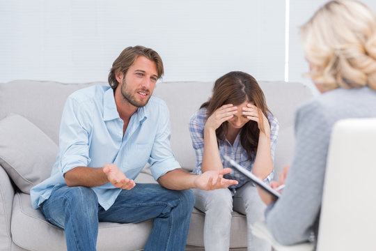 Young couple arguing and crying on the couch