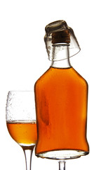 glass and bottle of alcohol on a white background.