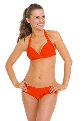 Fototapeta premium Smiling young woman in swimsuit looking on copy space