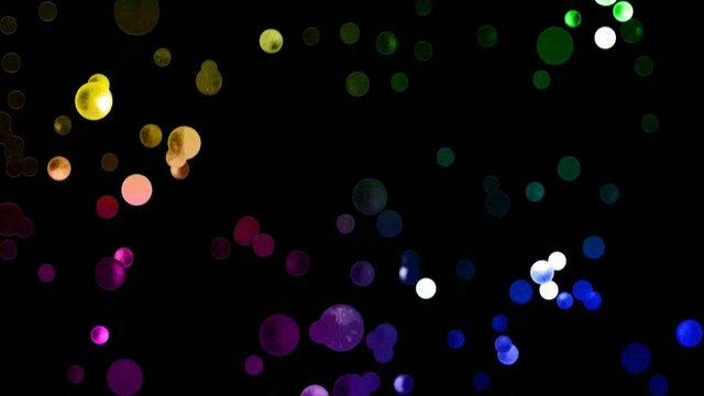 Paillettes brillantes multicolores qui montent sur fond noir