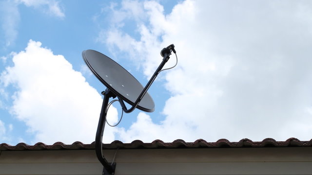 black antenna communication satellite dish over sky, time-lapse
