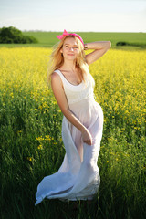 Fototapeta na wymiar Girl in white dress in a yellow field of flowers