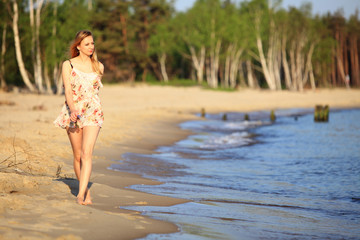 Young woman walking on a sandy beach