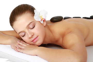 Obraz na płótnie Canvas Pretty woman receiving a therapy with hot stones in spa center