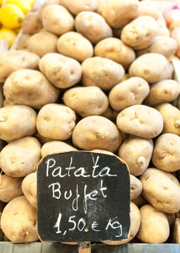 Pile of potatoes on market stall with price.