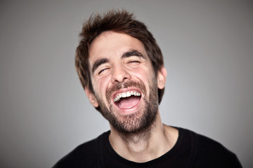 Portrait of a normal boy laughing isolated on white