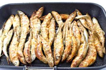 Fried small smelt fish on a barbecue grill  hotplate
