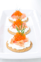 crackers with cream cheese, salted salmon and red caviar