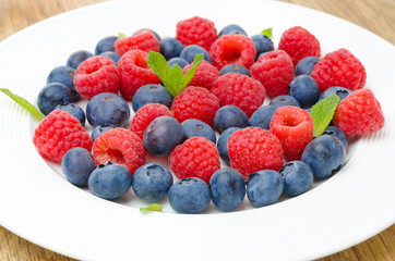 Fresh raspberries and blueberries on a plate