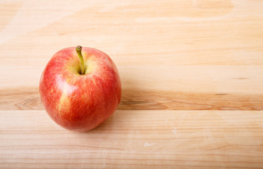 One Red Apple on Wood Cutting Board