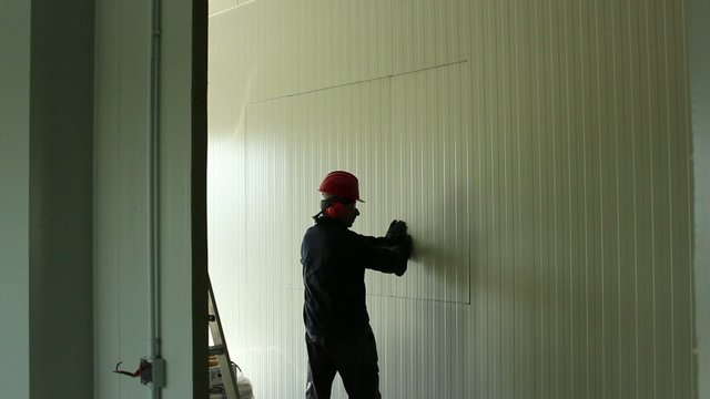 Operaio apre finestra nel muro