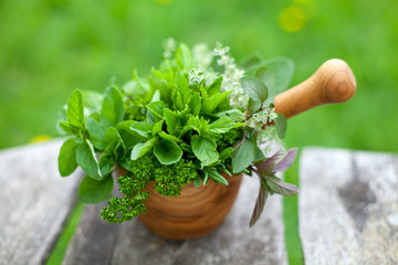 fresh herbs in a wooden mortar