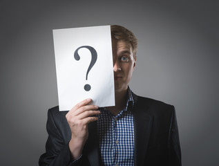 Young businessman holding  question mark