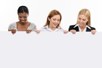 three businesswoman holding white board