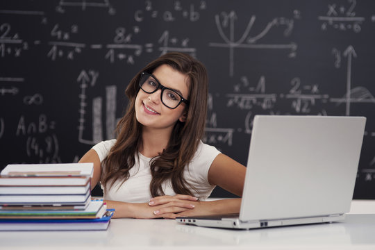 Portrait of pretty young female student in classroom - Powered by Adobe