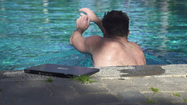 Swimmer with laptop in the pool