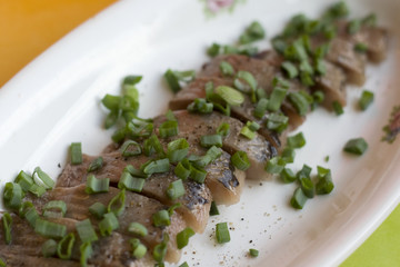 Herring fillet with green onion on a plate