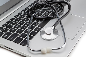 Medical stethoscope on a modern laptop, close-up. Isolated.